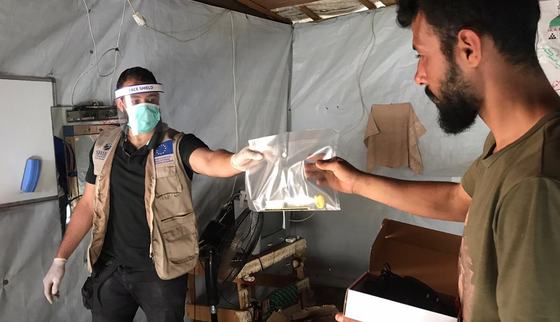 Distributing stationairy for remote lessons during corona_War Child_Lebanon_200528.jpg